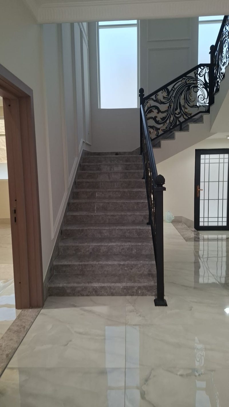 Marble staircase and polished hallway floor with an iron balustrade — Reef Al Ghadeer, Al Ain