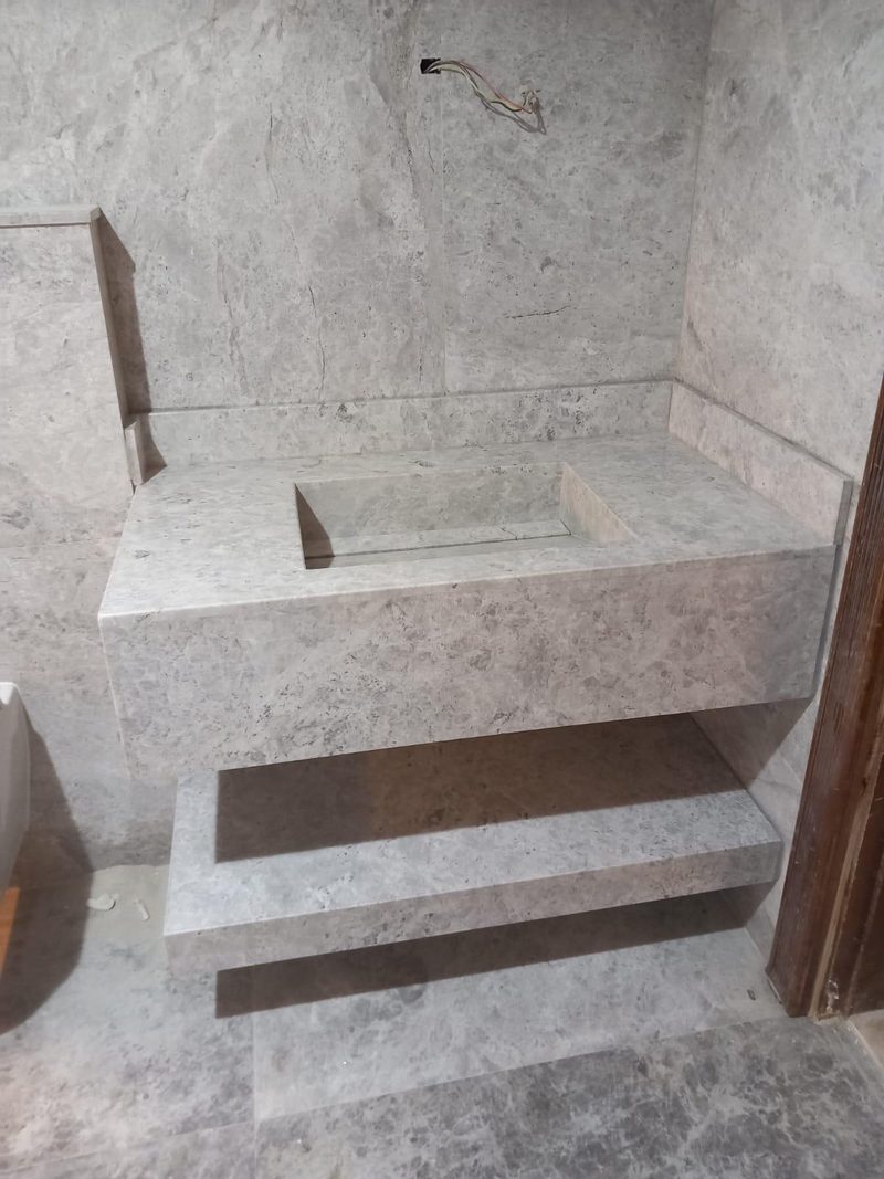 Marble vanity and stepped bench built into a tiled bathroom corner — Reef Al Ghadeer, Al Ain