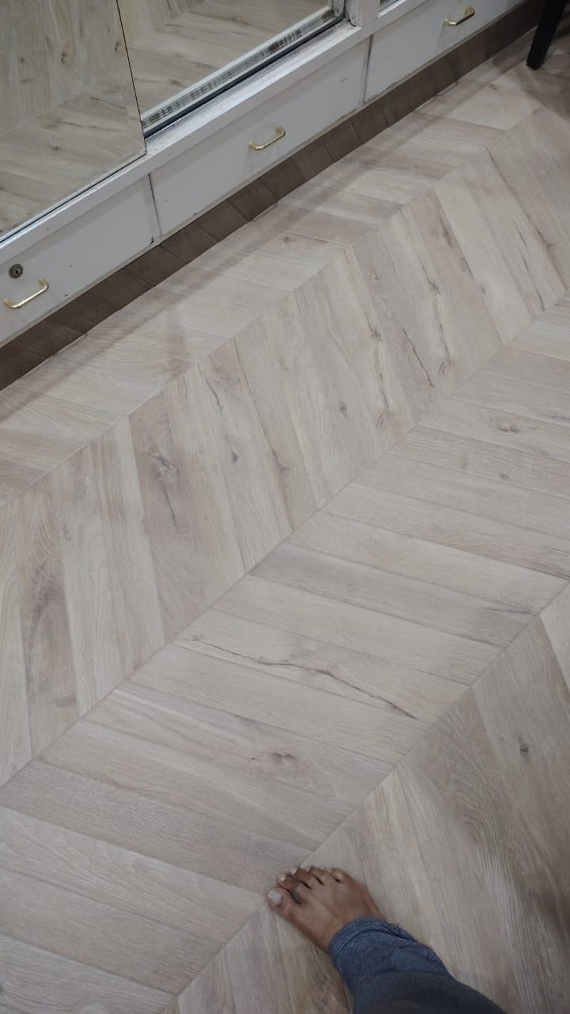 Herringbone timber-effect parquet flooring laid up to a glass shower screen — Reef Al Ghadeer, Al Ain