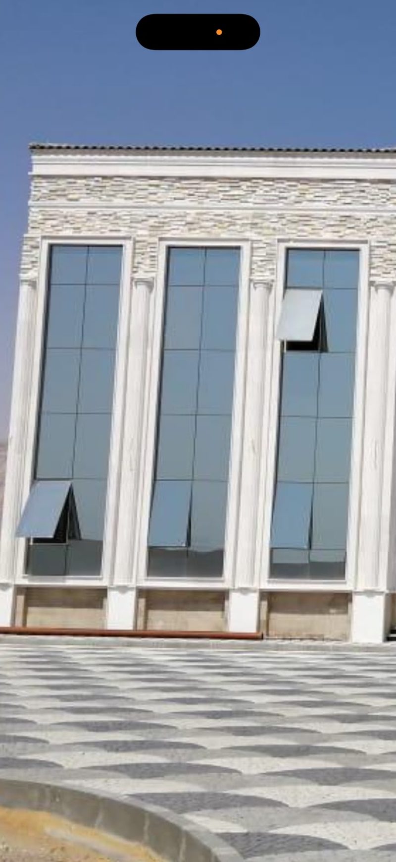 Completed villa frontage with rendered columns and tall arched windows — Reef Al Ghadeer, Al Ain