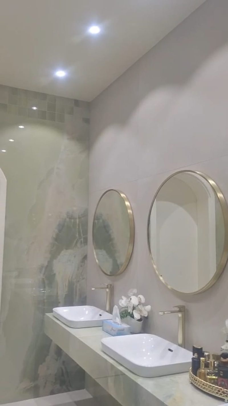 Washroom with twin basins, round mirrors and a stone counter — Reef Al Ghadeer, Al Ain